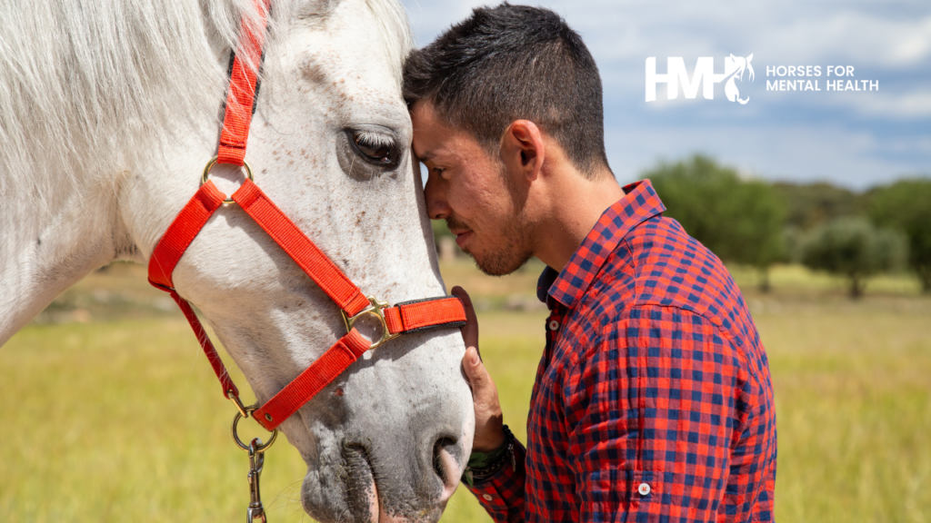 A young man and a horse touching foreheads