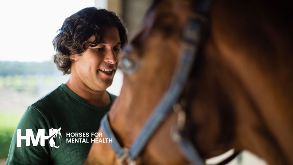 Smiling man with a horse in the foregrounc